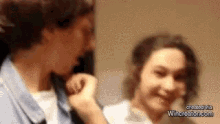 a man and a woman are standing next to each other and talking .