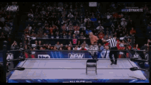 a wrestler in a ring with a aew logo