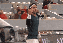 a man wearing a headband and a green shirt with the letter n on it