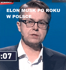 a man wearing glasses and a suit has a microphone in his mouth
