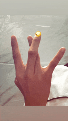 a close up of a person 's hand with a smiley face on the thumb