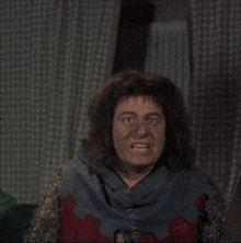 a man in a costume is making a funny face in front of a window .