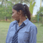 a woman wearing a striped shirt and tie looks to her left