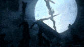 a silhouette of a person standing in front of a moon