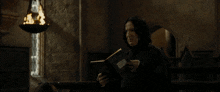 a man holding a piece of paper talking to a woman in a dark room