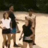 a blurry picture of a group of people standing on a sandy field