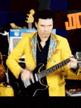 a man in a yellow jacket plays a guitar