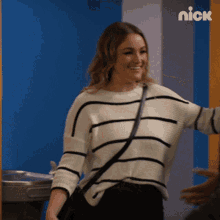 a woman wearing a black and white striped sweater is smiling