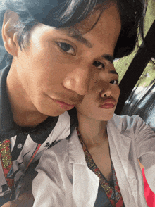a man and a woman are posing for a picture and the woman has a lanyard around her neck that says ' philippines '