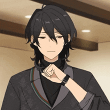 a young man with long black hair is wearing a watch on his wrist
