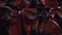 a group of people are sitting in a room with a red background .