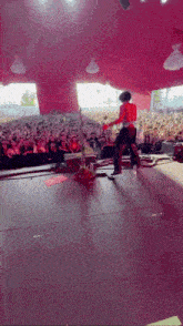 a man playing a guitar in front of a crowd of people