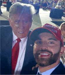 a man wearing a red hat that says america gain poses with donald trump