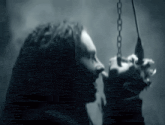 a woman with dreadlocks is holding a chain in her hand and screaming .