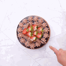 a chocolate cake with strawberries and kitkat pieces on top