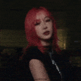 a woman with red hair and a black shirt is wearing a necklace .