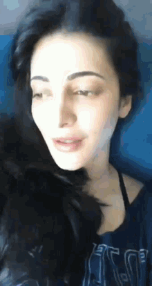 a close up of a woman wearing a blue shirt