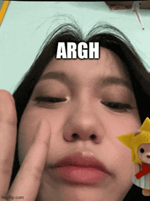 a close up of a girl 's face with the word argh on her forehead