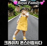 a little girl in a yellow dress is standing on a road with the words royal family behind her