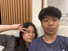 a boy and a girl are posing for a picture and the girl is making a funny face