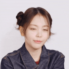 a woman in a denim jacket has a smiling emoji on her forehead