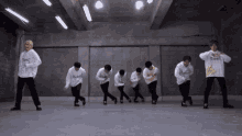 a group of young men are dancing in a room and one of them is wearing a sweatshirt that says ' a '