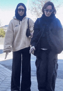 two women standing next to each other with one wearing a jacket that has the word ufc on it