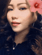 a close up of a woman 's face with a flower in her hair