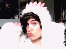 a boy wearing a white furry hat with pink spikes