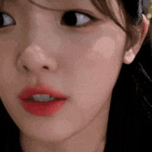 a close up of a woman 's face with red lipstick on her lips