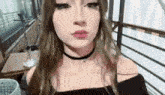 a young woman wearing a choker is making a funny face .