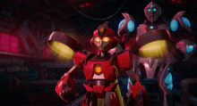 a couple of robots are standing next to each other in a room