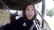 a woman is sticking her tongue out while standing under a shed .