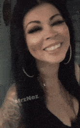 a woman wearing a black top and hoop earrings is smiling and has the name mrznez written on the bottom