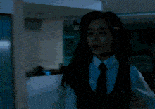 a woman in a white shirt and tie looks at the camera