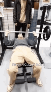 a man is bench pressing a barbell in a gym .