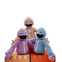 three stuffed animals are sitting on top of a brick box