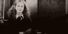 a black and white photo of hermione granger laughing with her mouth open .
