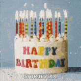 a birthday cake with candles on it and the words `` happy birthday shirley xx '' written on it
