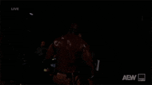 a man is standing in the dark with aew written on the bottom