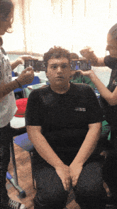 a girl taking a picture of a boy 's face
