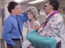 a man in a blue shirt is touching the nose of a woman