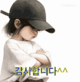 a little girl wearing a baseball cap has her arms crossed in front of a white background