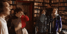a group of people singing in front of a microphone