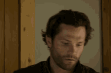 a man with a beard and long hair is looking down