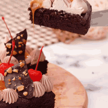 a cake with a cherry on top is being sliced by a knife