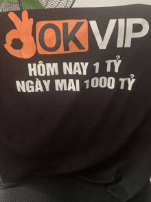 a black shirt that says ok vip in orange and white