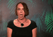 a woman sticking her tongue out in front of a palm tree background