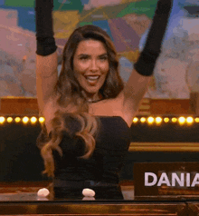 a woman in a black dress is standing in front of a sign that says " dania "