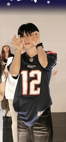 a person wearing a patriots jersey with the number 12